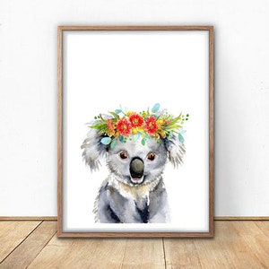 Puede incluir: Una pintura de acuarela de un koala con una corona de flores. El koala es gris y tiene una expresi&oacute;n linda. Las flores de la corona son rojas, amarillas y azules.