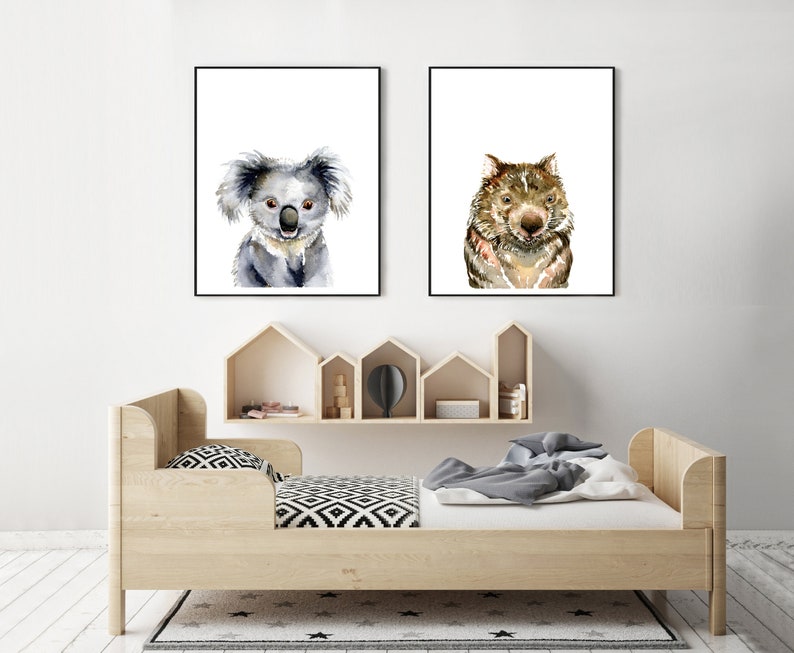 May include: Two framed watercolor paintings of animals. The left painting features a koala, and the right painting features a wombat. Both paintings have a white background.