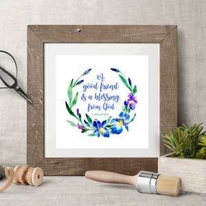 May include: A framed watercolor print with a floral wreath of blue and purple irises. The text reads "A good friend is a blessing from God - 1 Samuel 18:3".