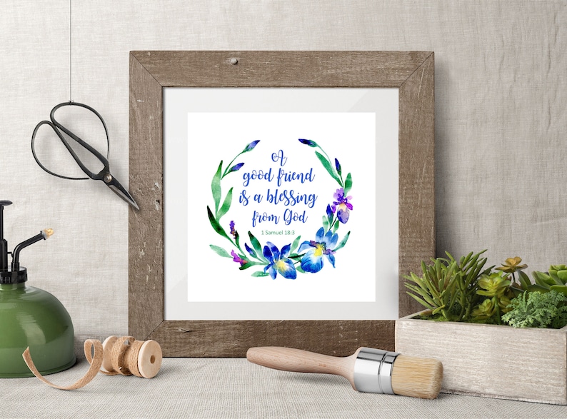 May include: A framed watercolor print with a floral wreath of blue and purple irises. The text reads "A good friend is a blessing from God - 1 Samuel 18:3".