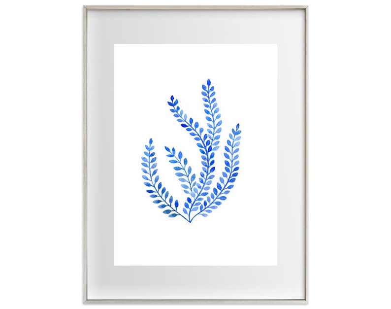 Puede incluir: Una impresi&oacute;n art&iacute;stica enmarcada con una ilustraci&oacute;n en acuarela de elementos bot&aacute;nicos azules. La obra de arte muestra un grupo de hojas estilizadas en tonos azules sobre un fondo blanco. El marco es plateado.