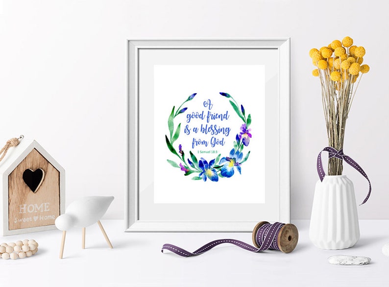 May include: A white framed print with a watercolor floral wreath and the text "A good friend is a blessing from God - 1 Samuel 18:1" in blue lettering.