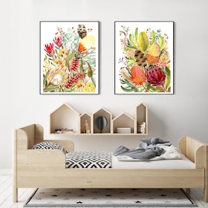 Puede incluir: Dos pinturas al agua enmarcadas de coloridas flores nativas australianas, incluyendo tonos rojos, amarillos y verdes. Las pinturas se exhiben sobre una cama de madera con un colch&oacute;n blanco y ropa de cama con estampado blanco y negro.