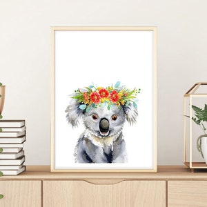 Puede incluir: Una pintura de acuarela de un koala con una corona de flores. El koala es gris y tiene la nariz negra. La corona de flores est&aacute; hecha de flores rojas, amarillas y naranjas.