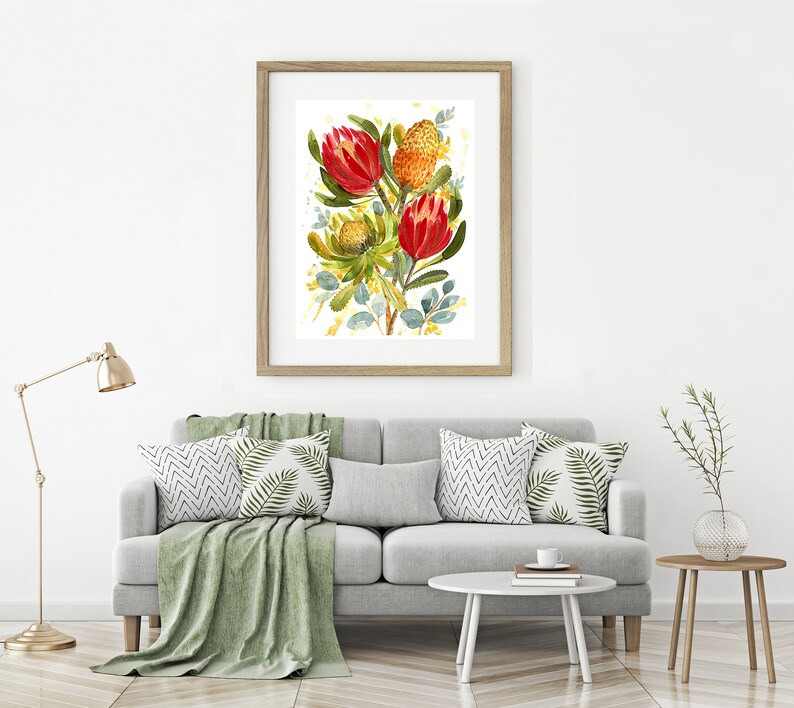 May include: A framed watercolor painting of a bouquet of red and orange protea flowers with green leaves on a white background.