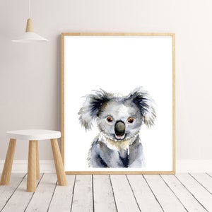 Puede incluir: Una pintura de acuarela de un koala con un pelaje gris claro, grandes ojos negros y una nariz negra. El koala est&aacute; mirando directamente al espectador con una expresi&oacute;n amigable.