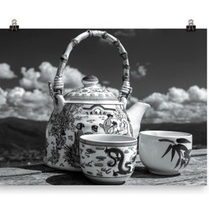 May include: A black and white ceramic teapot with a bamboo-style handle and a lid, decorated with detailed illustrations of figures and landscapes. Two matching ceramic tea cups are placed in front, one featuring a dragon and one with bamboo leaves.
