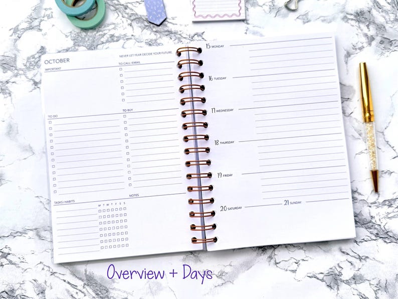 May include: An open planner with a copper spiral binding, displaying the month of October. The planner has sections for to-do lists, notes, and a weekly overview. A gold pen with a crystal-like design rests on the right side. The text "Overview + Days" is visible.