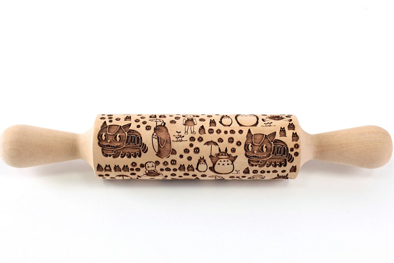 Puede incluir: Un rodillo de madera con un dise&ntilde;o grabado en marr&oacute;n y negro con personajes de la pel&iacute;cula animada Mi Vecino Totoro. El dise&ntilde;o incluye a Totoro, el Catbus y otros personajes de la pel&iacute;cula.