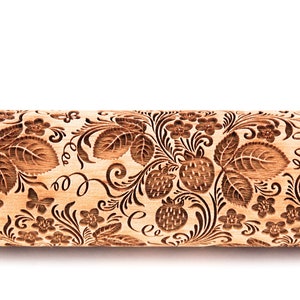 May include: A wooden rolling pin with an engraved design of strawberries, leaves, and flowers. The design is in a dark brown colour against the light brown wood.