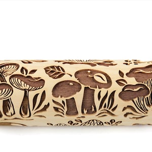 May include: A wooden rolling pin with a carved design of mushrooms and leaves. The rolling pin is light brown with dark brown carvings.