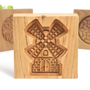 Puede incluir: Cuatro cortadores de galletas de madera, cada uno con un dise&ntilde;o diferente. El cortador del centro presenta un dise&ntilde;o de molino de viento. Los otros cortadores presentan un dise&ntilde;o circular.