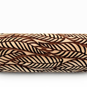 May include: A wooden rolling pin with a carved design of brown leaves on a white background.