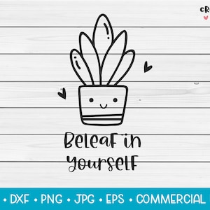 May include: A black and white line drawing of a potted plant with a smiling face and the words "Beleaf in yourself." Two small hearts are on either side of the plant. The background is a white wood grain.