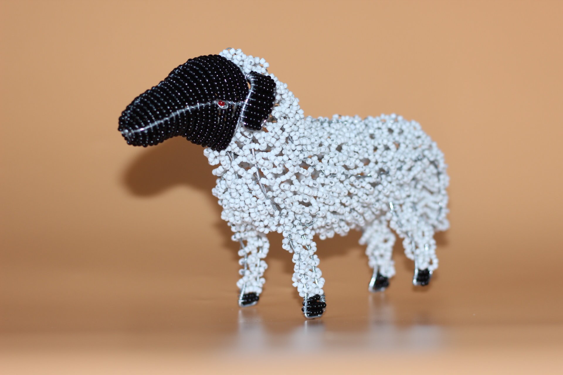 黒と白のビーズの羊。ビーズとワイヤーの南アフリカの動物のアート
