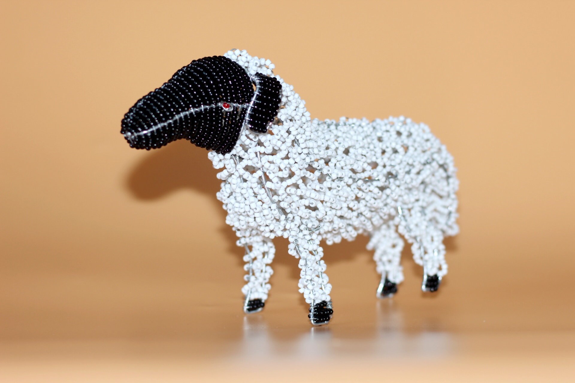 黒と白のビーズの羊。ビーズとワイヤーの南アフリカの動物のアート