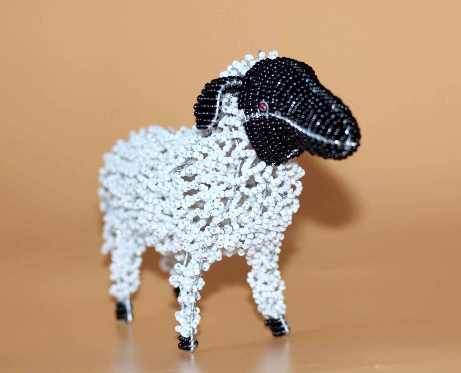黒と白のビーズの羊。ビーズとワイヤーの南アフリカの動物のアート