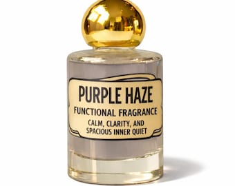 Puede incluir: Un frasco de perfume de vidrio transparente con un tapón esférico dorado brillante. La etiqueta presenta el texto PURPLE HAZE, FUNCTIONAL FRAGRANCE, CALM, CLARITY, AND SPACIOUS INNER QUIET en letras negras sobre un fondo crema con borde.