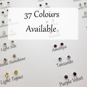 Puede incluir: Una tarjeta blanca con el texto "37 Colores Disponibles" en letras negras. La tarjeta está rodeada de pequeñas piedras de vidrio de colores, cada una etiquetada con un nombre de color diferente.