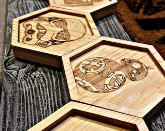 May include: Set of six wooden hexagonal coasters featuring Star Wars characters. The coasters are laser engraved with images of Darth Vader, R2-D2, BB-8, and the Millennium Falcon.