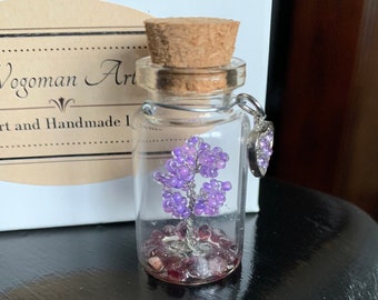 Миниатюрная фиолетовая скульптура из проволоки в бутылке.