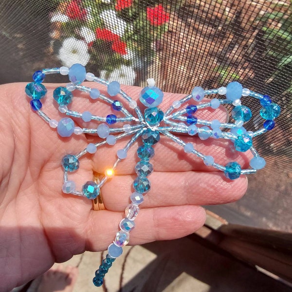 Exquisite light blue beaded dragonfly.  Made from imported polished glass beads.  It will bring a splash of color to your world.