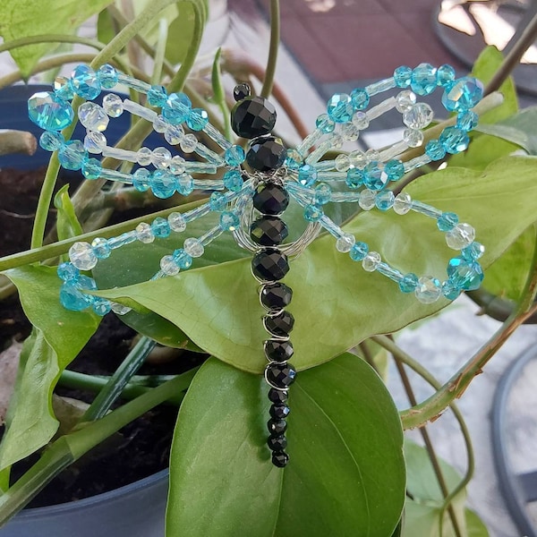 Exquisite light blue beaded dragonfly. Made from imported polished faceted glass beads.  It will add a splash of color to your world.