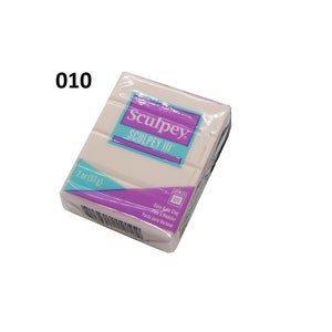 May include: A 2 ounce (57 gram) package of white Sculpey III oven-bake clay. The package is purple and blue with the text "Sculpey III" and "Oven-Bake Clay" printed on it.