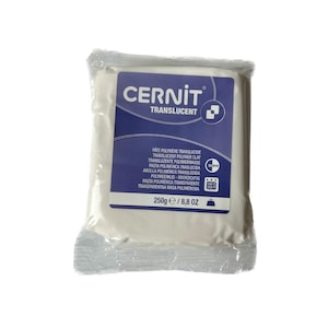 Puede incluir: Un bloque rectangular de arcilla polimérica translúcida Cernit en un envoltorio de plástico transparente. La etiqueta azul muestra la marca, el tipo de producto, un icono de horneado de 30 min, 130 grados Celsius y 250g de peso neto.