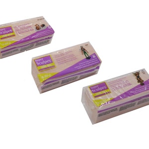 K&ouml;nnte beinhalten: Drei Packungen Super Sculpey Living Doll Polymer Clay. Jede Packung ist rosa und wei&szlig; mit violettem Text und einem Bild einer Puppe.