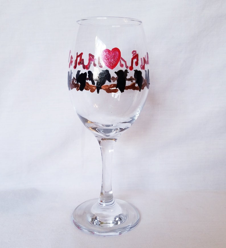 Wine glass features hand painted love birds on a brown branch with black birds and a red heart It make a lovely gift for any occasion!