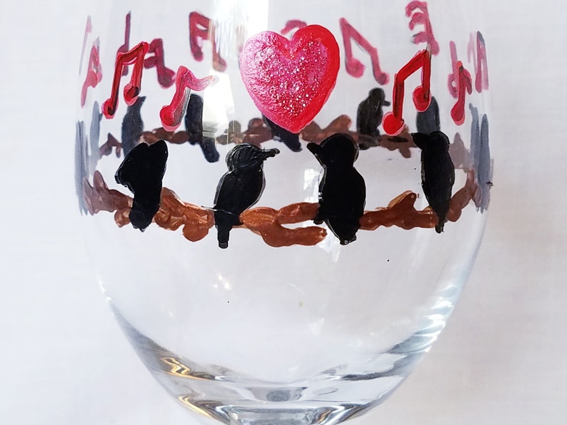 Wine glass features hand painted love birds on a brown branch with black birds and a red heart It make a lovely gift for any occasion!