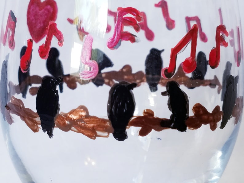 Wine glass features hand painted love birds on a brown branch with black birds and a red heart It make a lovely gift for any occasion!