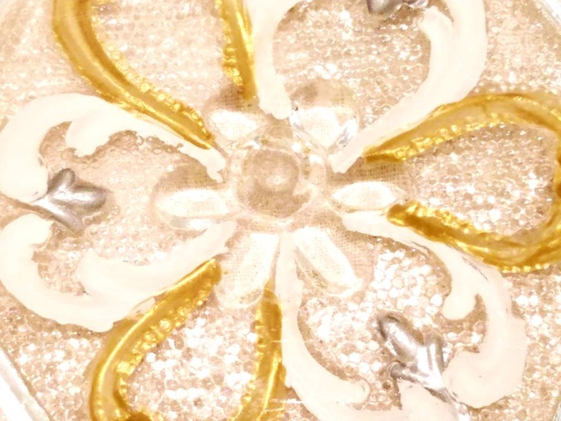 6 sided glass bowl has clear glass flowers silver and white heart shapes and raised dot designs. Scalloped edge gold embellished vines