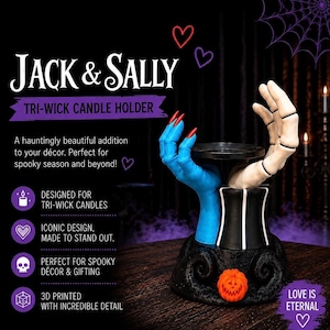 May include: A Jack & Sally tri-wick candle holder featuring a blue hand with red fingernails and a white skeletal hand emerging from a black base with white stripes and a small orange pumpkin. The text reads Jack & Sally Tri-Wick Candle Holder.