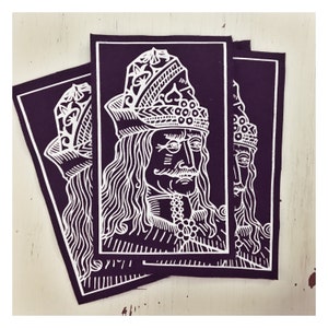 May include: Three black fabric patches with white embroidered images of a man with a crown and long hair. The man's face is detailed with a mustache and beard.