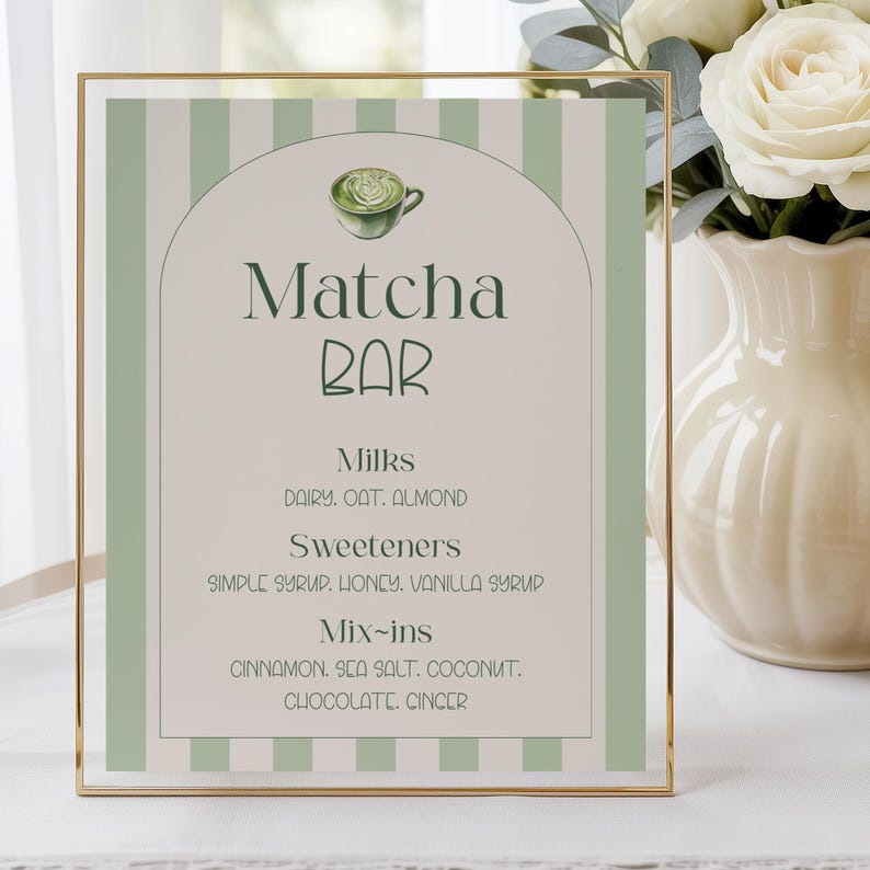 May include: A framed sign with a gold border and a light green and white striped background. The sign reads "Matcha Bar" with a graphic of a matcha drink. The sign lists milk, sweetener, and mix-in options.