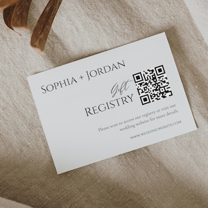 May include: A white gift registry card with the names "SOPHIA + JORDAN" at the top. The word "Gift" is in cursive, and "REGISTRY" is below. A QR code is on the right. Text below says to scan or visit the website.