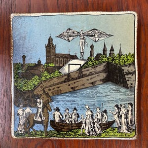May include: A vintage tile depicting a man flying with wings over a town. The tile is blue, green, and brown with a white border. The text "Schneider mit Ulm" is at the bottom of the tile.