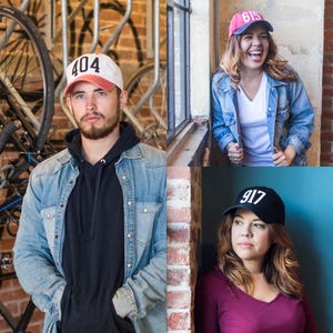 May include: Three people wearing baseball caps with numbers on them. The caps are in different colors and styles. The people are all smiling and looking at the camera.