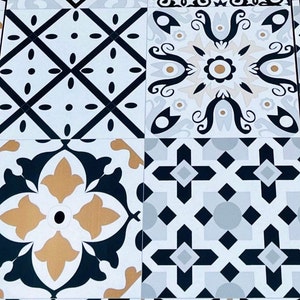 May include: Four square ceramic tiles with black, white, and gold geometric patterns. The tiles have a vintage style and are perfect for a bathroom or kitchen backsplash.