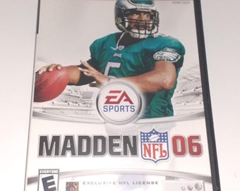 May include: PlayStation 2 video game case for Madden NFL 06. The cover features a football player in a green jersey with the EA Sports logo. The game is rated E for Everyone by the ESRB.