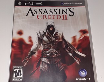 May include: A video game case for the PlayStation 3 console featuring the game Assassin's Creed II. The cover art features a hooded figure in a white and red outfit holding a hidden blade. The game is rated M for Mature by the ESRB.