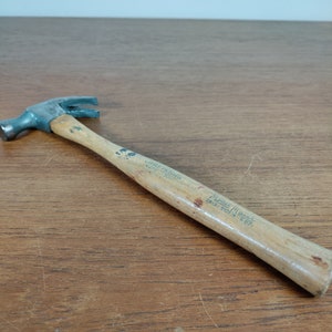 May include: A vintage hammer with a wooden handle. The handle is marked "Made in USA" and "16 oz."