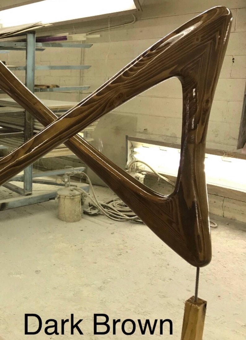 May include: Dark brown wooden sculpture with a triangular shape and a smooth, glossy finish. The sculpture is attached to a wooden base with a metal screw.
