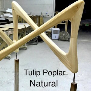 May include: Two wooden legs for a tulip table, made of poplar wood in a natural finish. The legs are shaped like a triangle with a rounded top and bottom. The text "Tulip Poplar Natural" is visible in the image.