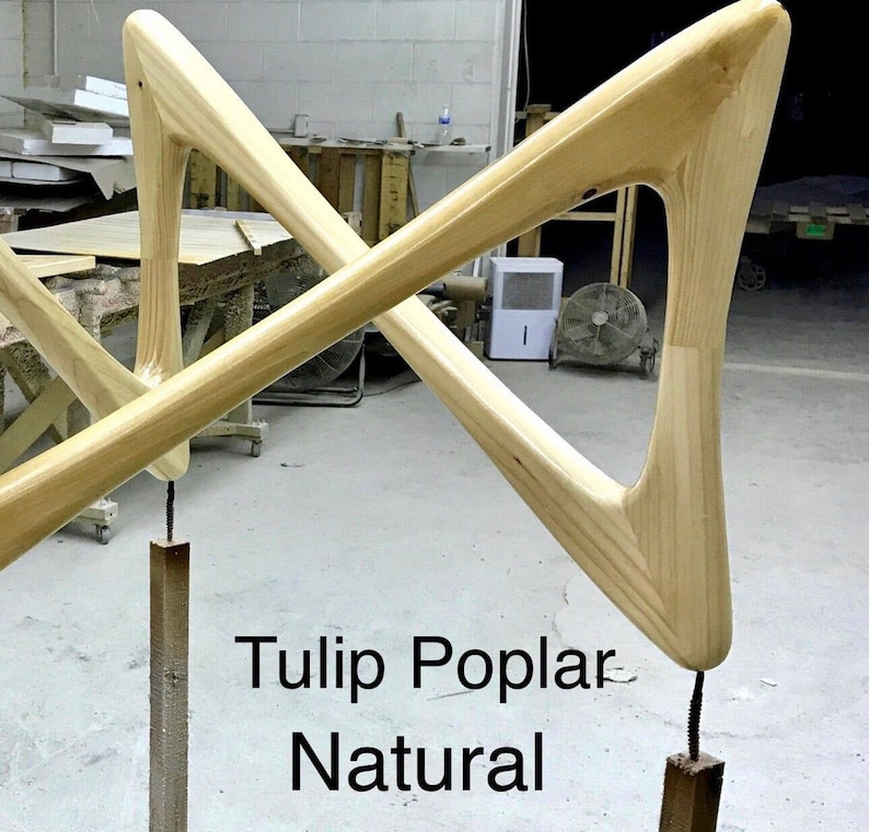 May include: Two wooden legs for a tulip table, made of poplar wood in a natural finish. The legs are shaped like a triangle with a rounded top and bottom. The text "Tulip Poplar Natural" is visible in the image.