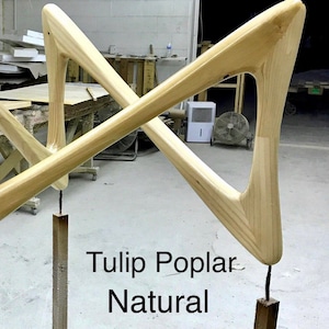May include: Two wooden legs for a tulip table, made of poplar wood in a natural finish. The legs are shaped like a triangle with a rounded top and bottom. The text "Tulip Poplar Natural" is visible in the image.
