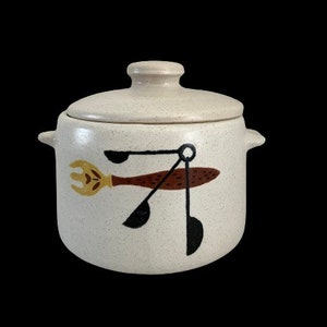May include: White ceramic crock pot with a lid. The crock pot has a brown and black design of a fork and spoon.