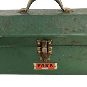 May include: Green metal toolbox with a silver handle and a latch. The toolbox has a sticker on the front that says "PARK MODEL".